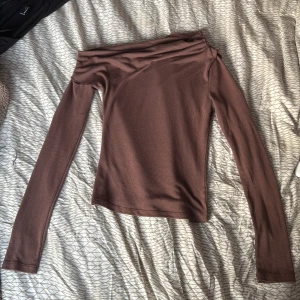 Brun offshoulder topp från Nelly - Säljer en snygg brun offshoulder topp från Nelly. Toppen har långa ärmar och en tight passform som framhäver figuren. Använd ett fåtal gånger 💕