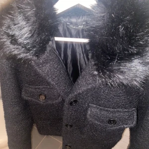 Svart kappa med pälsdetaljer - Säljer nu min svarta jacka med fejk päls ifrån Chealsea. Väldigt lik meotine jackan. Jag har bytt ut knapparna till svarta då dom var bruna ifrån början. Den passar både till vintern och våren. Priset går att diskutera. Snabbt köp=lägre pris. Skriv gärna för flera bilder.💗