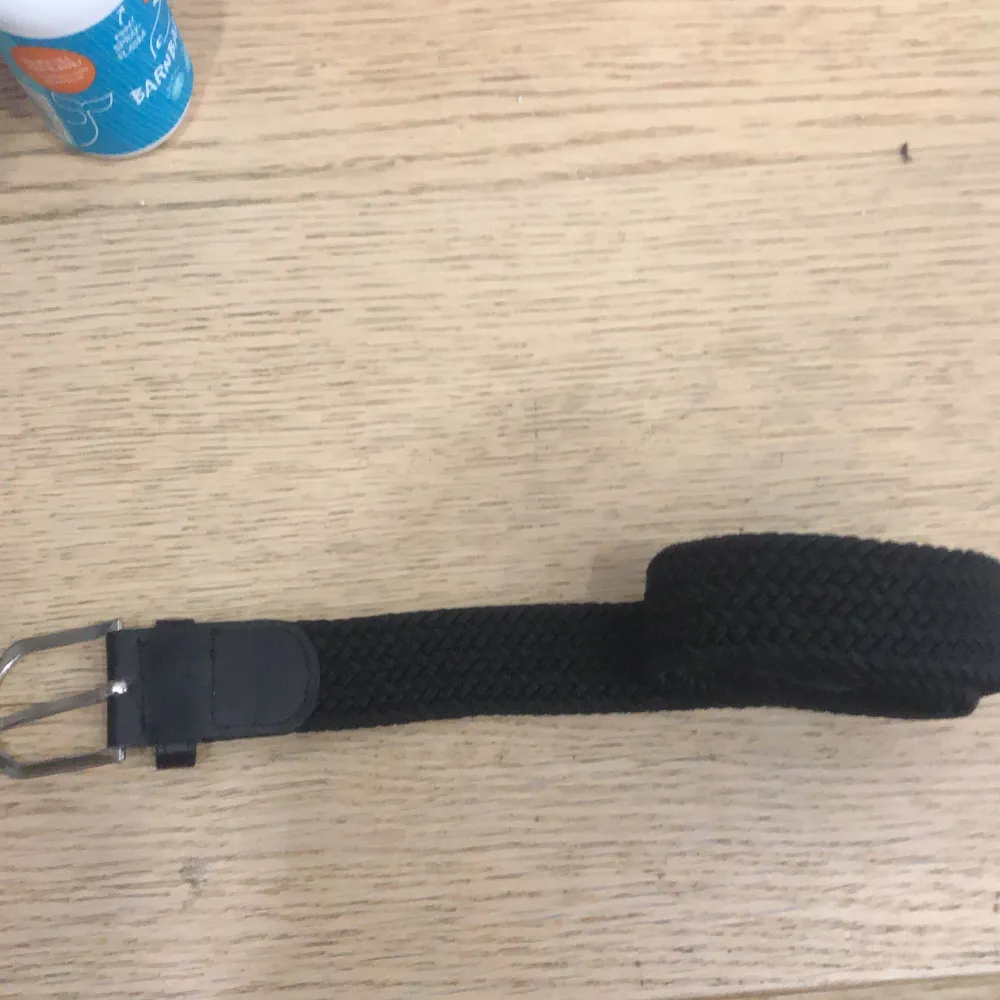 Snyggt svart flätat bälte med en klassisk metallspänne. Perfekt för att ge en stilren touch till din outfit. Bältet är flexibelt och passar till olika storlekar.. Asusteet.