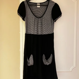 Randig svart och vit klänning - Klänning, randigt mönster i svart och vitt med fickor på framsidan och knyte bak💕💕