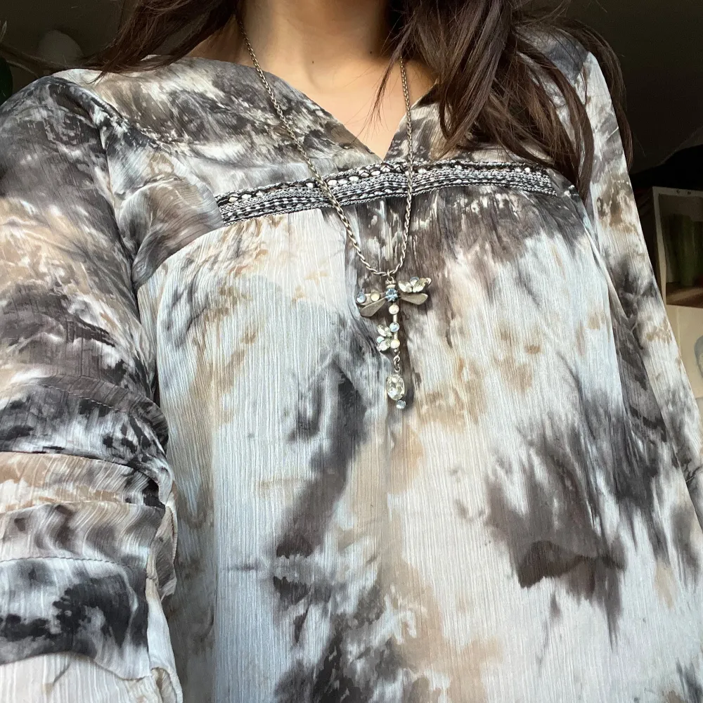 En fin blus med ett nästan batik mönster. Fin detalj vid bysten och ett härligt luftigt material. Storlek 36/38 alltså S på lappen.. Puserot.
