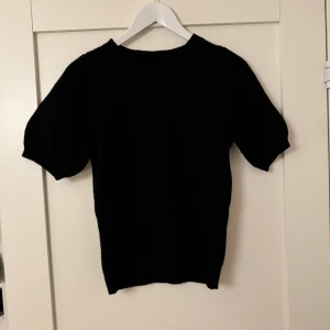 Svart stickad tröja från Vero Moda - En basic svart kortärmad stickad tröja som passar både vardagen och finare tillställningar, lite längre i modellen. Den är ganska luftig så passar även bra under lite varmare dagar. Lite små nopprig på enstaka ställen🖤 Nypris: 300kr