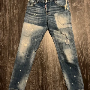 Blå jeans från Dsquared2 - Snygga blå jeans från Dsquared2 med slitna detaljer och en cool, distressed look. De har en klassisk femficksdesign och knappgylf. Perfekta för en avslappnad stil med en touch av edge. Cool girl jean, dam st 