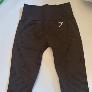 Bruna leggings från Gymshark - Snygga bruna leggings från Gymshark med hög midja och diskret mönster. Perfekta för träning med en tight passform som ger bra stöd. Tillverkade i ett stretchigt material för maximal komfort.