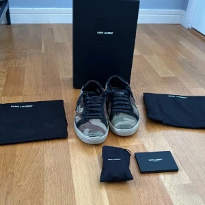 Saint Laurent camo  - Säljer mina saint Laurent camo skor som är i storlek 39. Skon har lossnat från sulan på flera ställen och är inte i det bästa skicket allt originellt med kommer. Hör av er vid frågor och vid snabb affär kan priset sänkas rejält!