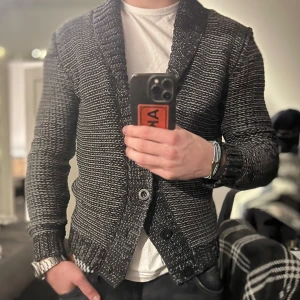 Svart och vit kofta med knappar - Snygg svart och vit kofta från WE med knappar framtill. Den har en ribbad krage och är perfekt för kyligare dagar. Passar bra till både jeans och chinos. För med frågar är det bara att skriva!