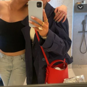 Handväska  - Säljer min super fina väska från Arket i denna röda färgen, den röda färgen säljs inte i butik längre. Väskan är sparsamt använd och i nyskick. Helt perfekt crossbody väska eller bara ha i handen🪅🩷 skriv för mer frågor/funderingar. De sista bilderna är för att visa modellen på väskan. Nypris 1390