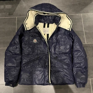 Moncler jacka - säljer nu denna riktigt snygga moncler jacka🤩 Det är en äldre modell och är vintage. Det gör så att man inte kan andvända qr kod då det inte fanns när denna gjordes. Den är i ett mycket bra skick för att vara gammal men däremot har det 2 hål som jag sytt in. Dock är det inget som syns men kom privat så skickar jag. Men med mera frågor och bilder så är det bara att skriva, jag svarar så fort jag kan!🤝🙌