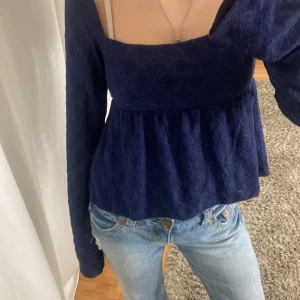 Mörkblå topp från Nelly - Säljer en mörkblå topp från Nelly med ötsvängda långa ärmar som knappt har används!