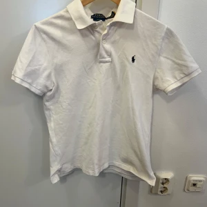Vit pikétröja från Ralph Lauren - Säljer en snygg pikétröja från Ralph Lauren. Storlek L 14/16 år. Nypris 1000 kr. Hund i hemmet!