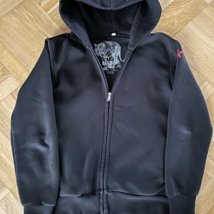 Svart hoodie från Bastille - Säljer en snygg svart hoodie från Bastille med ett stort tryck på baksidan. Storlek S. Tillverkad i Italien av 100% bomull. 