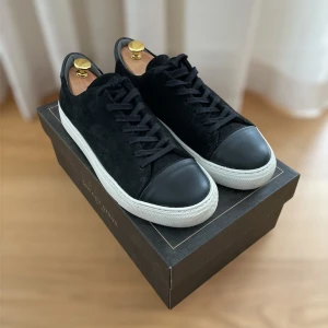 Svarta sneakers från sneaky Steve - Snygga svarta sneakers från sneaky Steve i mocka med vita sulor och snörning. Perfekta för en stilren look. Skorna har en diskret design med en svart tå och häl. Skorna är i modell lescape och har ett ny pris på 1699 kr. Låda med följer. Pris kan gå ner vid snabb affär