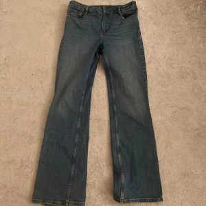 Blå bootcut jeans - Tjejkläder!, Snygga blå bootcut jeans med klassisk design. Perfekta för en avslappnad stil. De har en bekväm passform och är tillverkade i ett slitstarkt material.