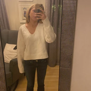 Vit stickad tröja från BikBok - Säljer en stilren vit stickad tröja från BikBok i storlek XS. Tröjan har en v-ringad design och långa ärmar, perfekt för kyligare dagar. Den är mjuk och bekväm, idealisk för en avslappnad look. Använt fåtal gånger