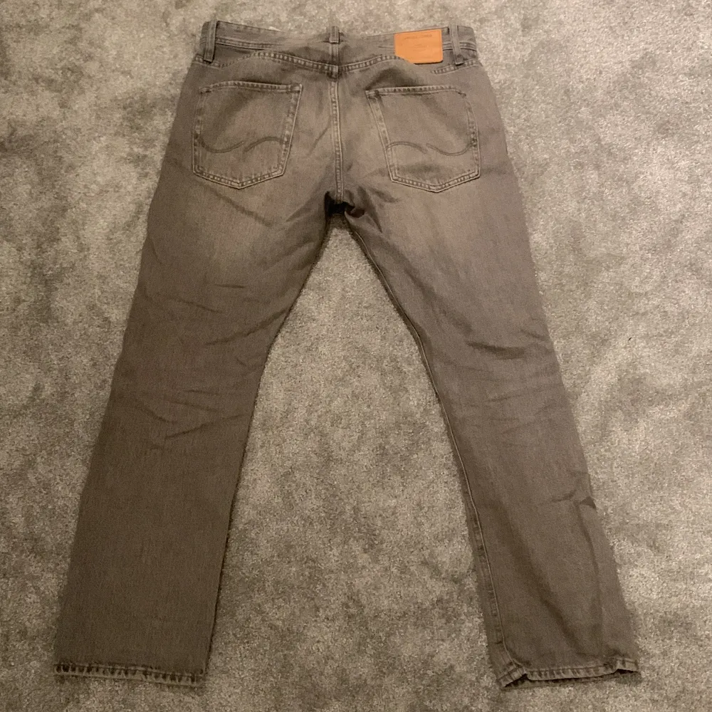 Snygga grå jeans från Jack & Jones med klassisk femficksdesign. Tillverkade i slitstarkt denim med en bekväm passform. Perfekta för en avslappnad stil.. Farkut & Housut.