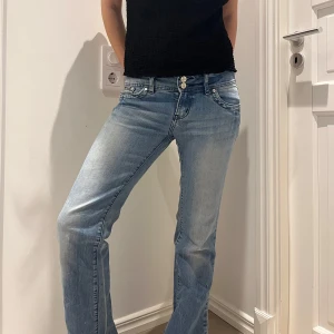 Blå jeans med bootcut - Snygga blå jeans med bootcut-stil och klassisk femficksdesign. De har en knapp- och dragkedjestängning framtill och är perfekta för en avslappnad look.
