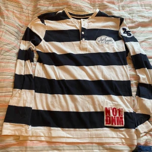 loongsleeve - tyg vid kragen som ska se ut som en tröja under, sitter som en S