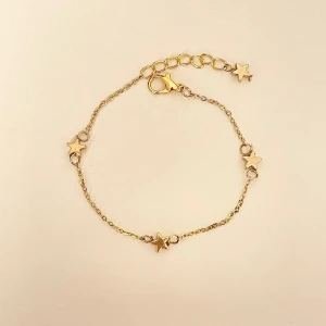 Guldarmband med stjärndetaljer - Säljer ett superfint handgjort guldarmband med små stjärnor som detaljer. Armbandet har en justerbar kedja och en säker klolås. Perfekt för att lägga till lite stjärnglans till din outfit!