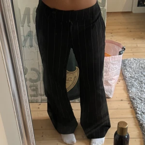 Lågmidjade randiga kostymbyxor - Randiga lågmidjade kostymbyxor, insydda vid båda höfterna (se bilder) men ingenting som syns! Skulle säga att de passar en M, raka ben men nästan lite bootcut (se bild där med💕)