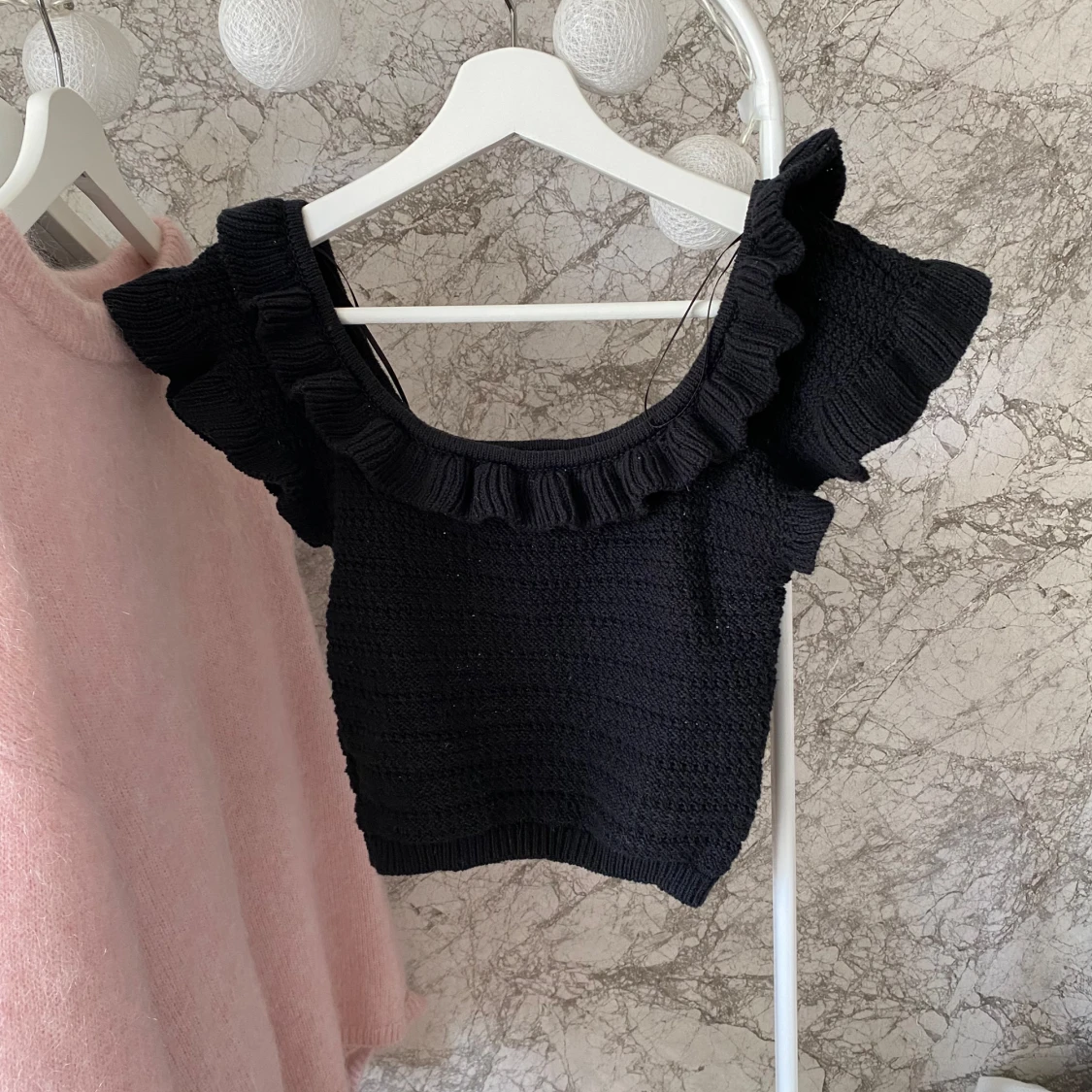 Svart stickad topp med volangdetaljer