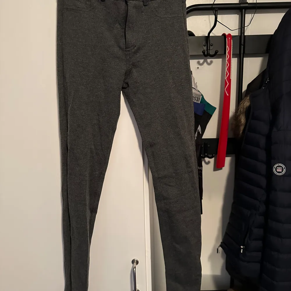 Säljer ett par grå leggings i mycket bra skick. De är tighta och perfekta för både vardag och träning. Materialet är mjukt och stretchigt, vilket gör dem superbekväma att ha på sig. De har en enkel design med fickor baktill och en knappdetalj fram. Passar perfekt till höst- och vintergarderoben!. Jeans & Byxor.