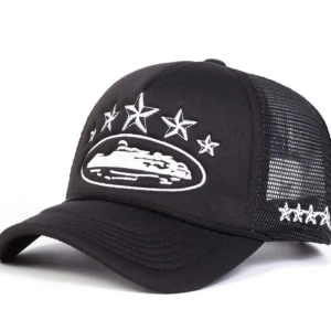 Svart keps med stjärnor - Snygg svart keps med vit broderad design av stjärnor och ett coolt motiv på framsidan. Kepsen har ett nät på baksidan för bra ventilation och en böjd skärm för en klassisk look. Perfekt för både vardag och fest!