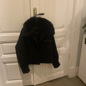 Svart jacka med pälskrage från Meotine - Säljer en snygg svart jacka från Meotine i storlek S/M. Den har en lyxig pälskrage och är perfekt för kyliga höst- och vinterdagar. Jackan är i mycket bra skick och har en stilren design som passar till det mesta. Perfekt för dig som vill hålla stilen i kylan! 🖤