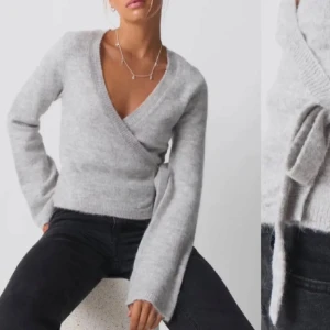 Grå omlottstickad tröja gina - Superfin grå omlottstickad tröja med v-ringning och långa ärmar. Perfekt för höst och vinter, den är både stilren och mysig. Tröjan har en knytning i sidan som ger en snygg detalj. Säljs på grund av att den inte kommer till användning, inga defekter enbart lite nopprig men inget man tänker på💕