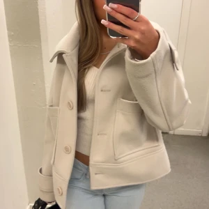 Beige kappa Kappahl  - Säljer en superfin beige kappa i mycket bra skick. Perfekt för att hålla stilen när det är lite kyligt ute! Köptes förra året för 900kr. Priset går att diskuteras!
