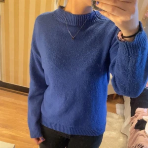 Blå stickad tröja - Säljer en snygg blå stickad tröja i mycket bra skick. Använt ca 3 ggr. Den har en klassisk design med långa ärmar och ribbade kanter vid hals, ärmslut och nederkant. Perfekt för kyliga dagar och passar till både vardag och fest. Storleken är S och den är superbekväm att ha på sig! 💙sticks INTE