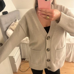 Beige kofta med knappar - Mysig beige kofta i bra skick med stora knappar framtill. Den har långa ärmar och praktiska fickor. Perfekt för höst och vinter, och passar till både vardag och mysiga hemmakvällar. 🧥✨ Den är lite stor i storleken så den är mer som s-m❤️