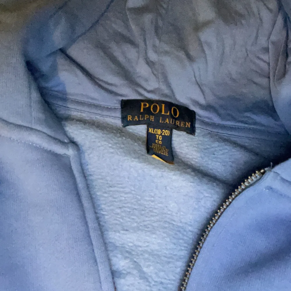 Säljer en snygg blå hoodie från Polo Ralph Lauren i bra skick. Den har en dragkedja framtill och en liten logga på bröstet. Perfekt för höst och vår, och den är superbekväm med sin mjuka insida. Passar perfekt för en casual look eller när du bara vill mysa hemma. 🌀 Ordinare pris 1300kr. Tröjor & Koftor.