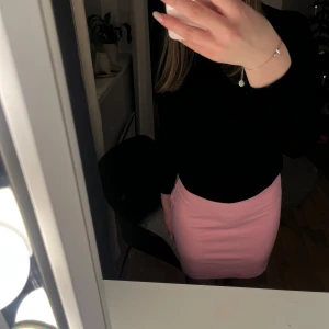 Rosa kortkjol - Säljer en superfin rosa kortkjol i tight passform. Perfekt för både vardag och fest! Kjolen är i ett mjukt och bekvämt material som formar sig snyggt efter kroppen. Passar perfekt till en enkel topp eller en mer dressad blus. Ett måste i garderoben för alla som älskar stilrena plagg!