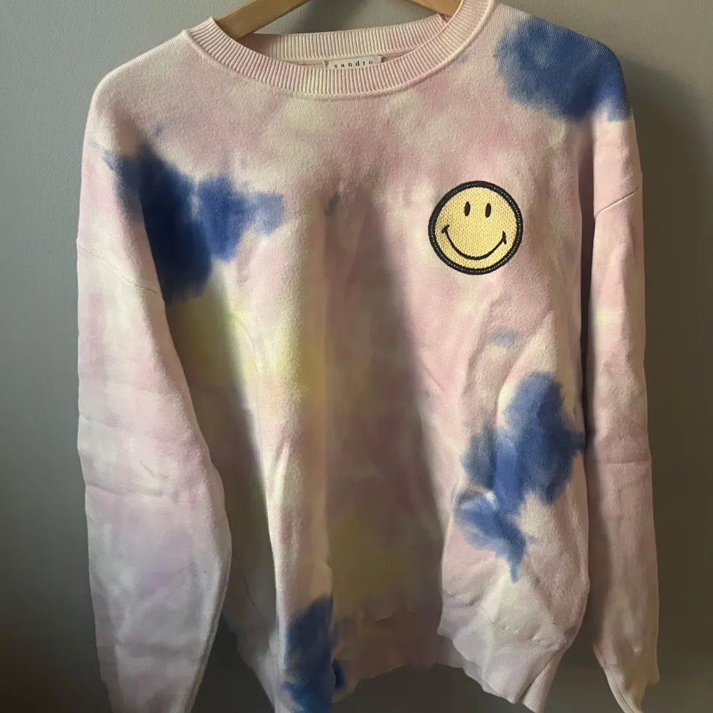 Supercool tie-dye tröja i pastellfärger med en glad smiley på bröstet. Perfekt för att liva upp garderoben! Tröjan har långa ärmar och en avslappnad passform. Perfekt för både vår och sommar.. Tröjor & Koftor.