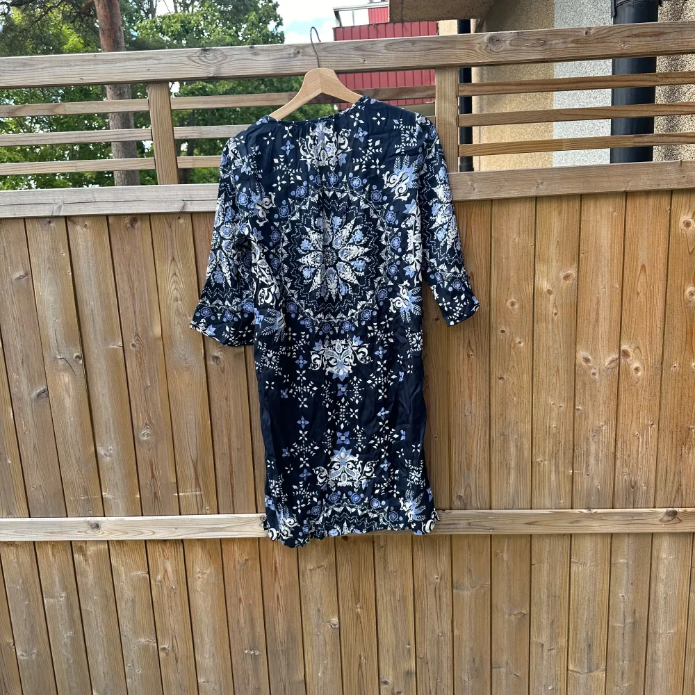 Snygg mönstrad klänning i mörkblått med vita och ljusblå detaljer. Klänningen har en v-ringning och trekvartsärmar, perfekt för en stilfull look. Den är tillverkad i ett mjukt och bekvämt material. Från märket Odd Molly i storlek 1 som enligt deras storleksguide motsvarar en storlek S. Helt ny med tags. . Mekot.