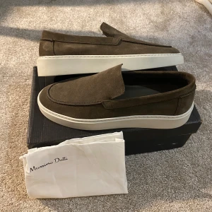 Bruna Suede loafers från Massimo Dutti - Snygga bruna loafers i mocka från Massimo Dutti. Skorna har en stilren design med en vit sula som ger en modern touch. Perfekta för en avslappnad men ändå elegant look. Endast provade annars helt nya. Box och dustbag ingår också. Storlek 43, handgjorda i portugal.🇵🇹 