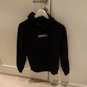 Svart hoodie och byxor från Hoodrich - Säljer en svart hoodie och matchande byxor från Hoodrich. Hoodien har en klassisk design med luva och en stor ficka framtill. Byxorna är mjuka och sköna. Setet är köpt från JD sport är ett plagg med bra och långvarig kvalité. Nypris 1700kr.