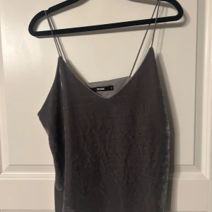 Grå sammetstopp från Bik Bok - Snygg grå sammetstopp från Bik Bok med tunna axelband och v-ringning. Perfekt för en stilren look.