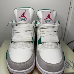 Nike Air Jordans i vitt och grönt - Snygga Nike Air Jordans i vitt med gröna och grå detaljer. Skorna har en klassisk snörning och en bekväm sula. Perfekta för dig som vill ha en stilren och sportig look.