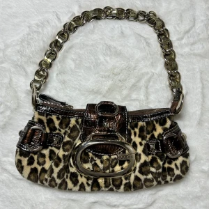 Guess handväska leopard  - Leopard guess väska. 30x14 cm. Superfint skick, dock är dragkedjan lite trög men inget som stör. Köp sker via köp nu, jag postar inom 24h.   Kvar tills markerad såld 