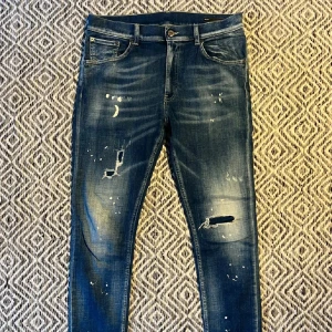 Dondup Jeans - Riktigt snygga blå jeans från Dondup med slitna detaljer och färgstänk. säljer pga att de är för små. Knappt använda. 