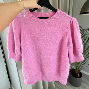 Rosa tröja från Vero Moda - Säljer en söt rosa tröja från Vero Moda med puffiga ärmar och ribbade muddar. Perfekt för en mysig dag. Tröjan har en rund halsringning och är gjord i ett mjukt material. Nopprig, se sista bilden.