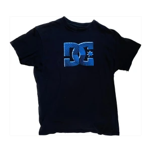 Svart t-shirt från DC - Snygg svart t-shirt från DC med blå logga, inte använd super mycket, bra skick. Skriv vid frågor eller funderingar, pris kan diskuteras!