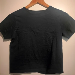 Marinblå t-shirt - Säljer en enkel svart t-shirt i bomull. Den har en klassisk rund hals och korta ärmar. Perfekt för en avslappnad stil. Passar mig som har storlek XS/S