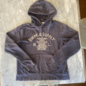 Ralph Lauren denim and supply hoodie  - Skick: 5/10. Kolla på bilderna, den är i ett vintage skick och har flertalet hål.   Märke: Ralph Lauren   Storlek: L  Färg: blå ✅Tar även byten på allt 