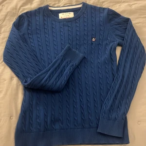 Blå stickad tröja från Bondelid - Säljer en snygg blå stickad tröja från Bondelid med kabelstickat mönster, i bra skick.