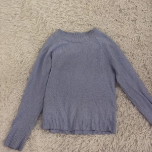 Ljusblå stickad tröja - Säljer en mysig ljusblå stickad tröja med långa ärmar och ribbstickade muddar vid ärmslut och nederkant. Perfekt för kyliga dagar. Passar bra till jeans eller kjol. 💙
