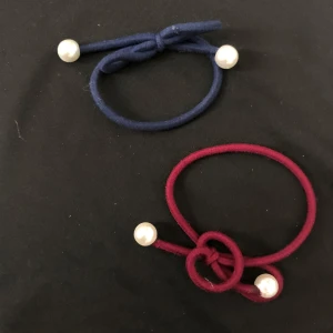 Hårsnoddar med pärlor - Två elastiska hårsnoddar i marinblått och vinrött, dekorerade med vita pärlor. Perfekta för att ge en elegant touch till din frisyr.