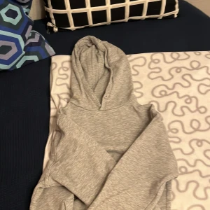 Grå hoodie från Dressmann - Säljer en stilren grå hoodie från Dressmann. Perfekt för en avslappnad look med sin mjuka och bekväma passform. Den har en klassisk huva och dubbel ficka framtill. Passar bra till både jeans och joggers. Det finns små tecken på användning, men inget som man lägger märke till vid första anblick. Säljes eftersom den blivit för liten. 