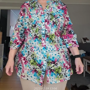 Färgglad blommig blus från Esmara - Säljer en färgglad blus från Esmara med blommigt mönster i rosa, blått och grönt. Blusen har trekvartsärmar med knapp nertill och slejf så dom kan rullas upp. Knappar framtill och plisse'veck. Knytband i sidan. 